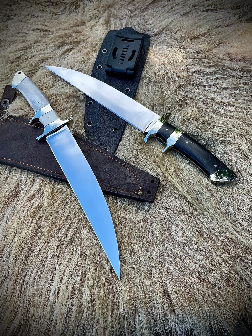 Два ножа Boar Hunter со светлой и темной рукоятями лежат на животном меху рядом с ножнами.